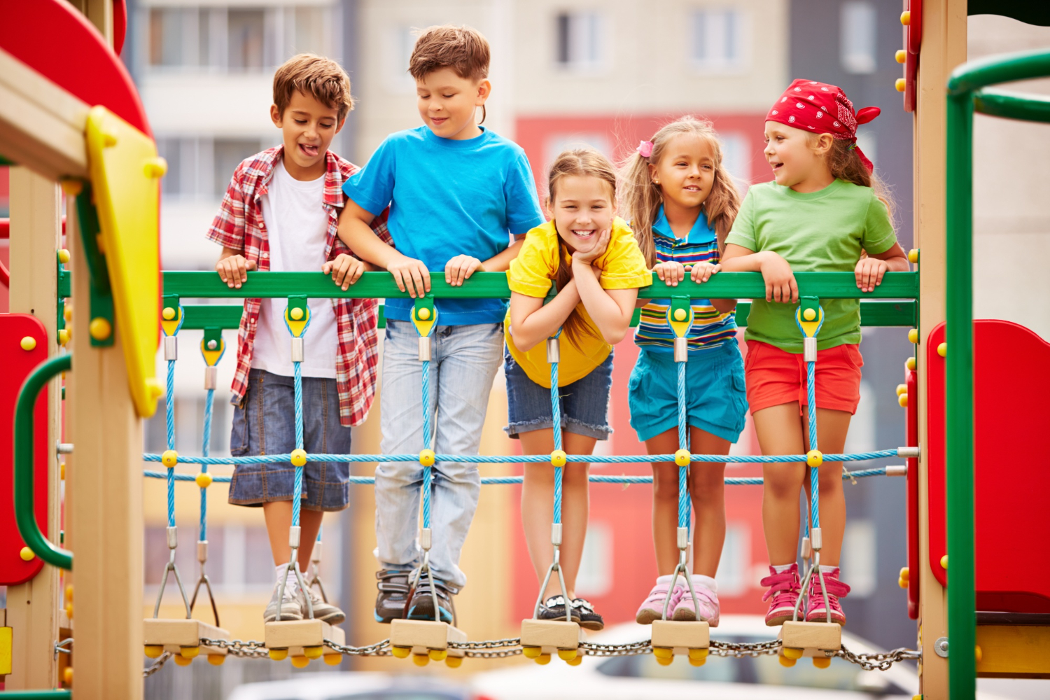 Grupo de crianças no parque infantil sorrindo sob um brinquedo de madeira