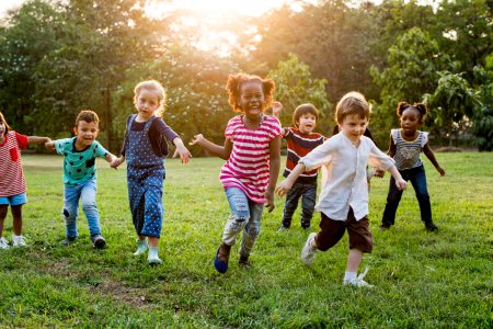 7 Crianças brincando em um parque com as mãos dadas