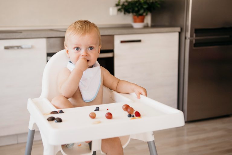 Como conciliar a amamentação e a introdução alimentar? Bebe numa mesa para bebe comendo frutas